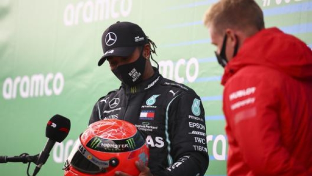 Lewis Hamilton riceve il casco di Schumacher dal figlio Mick. Ap