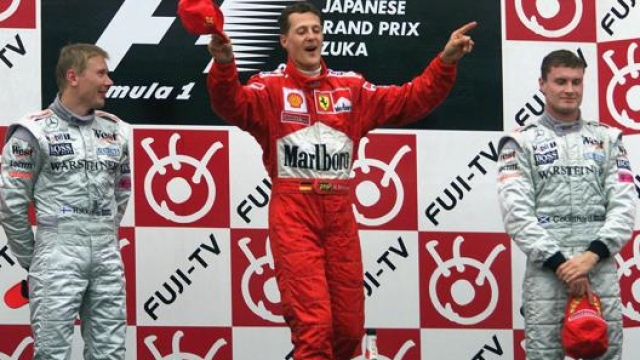 Schumacher sul podio di Suzuka mentre “dirige l’orchestra durante l’inno italiano. EPA
