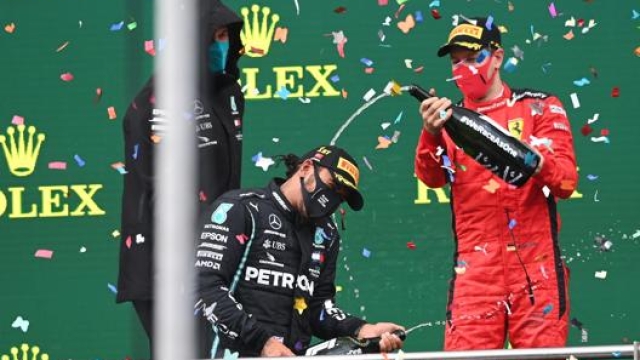 Sebastian Vettel (a destra) festeggia con Hamilton sul podio. Epa