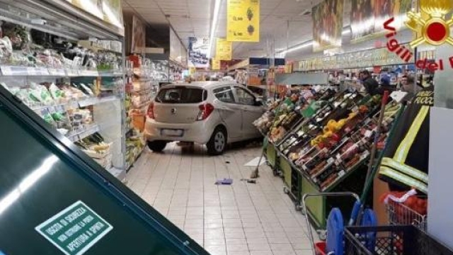 L'auto che ha sfondato la porta antipanico del supermarket, in primo piano, per un errore di manovra del guidatore