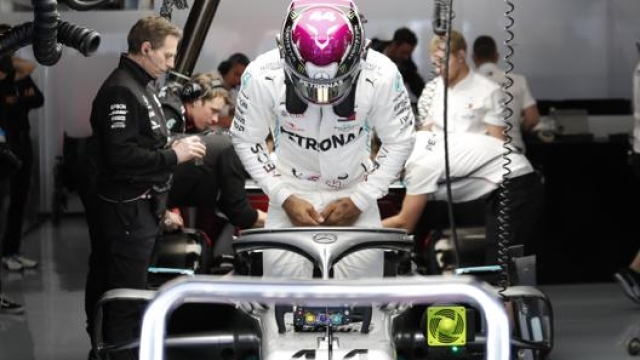 Lewis Hamilton si cala nell’abitacolo della sua Mercedes. Lapresse