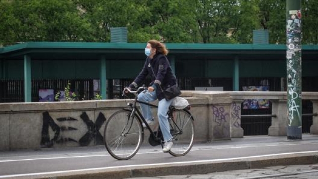 Una donna su una ciclabile di Milano. Ansa