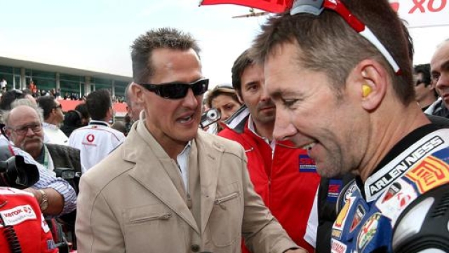 Michael Schumacher si complimenta con Troy Bayliss a Portimao nel 2008. Epa