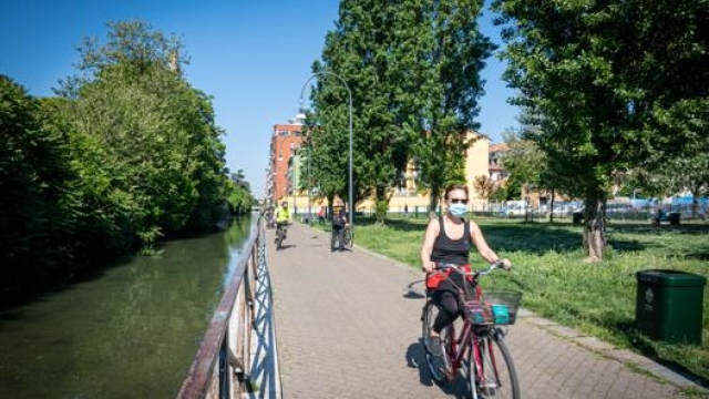 Ciclisti lungo il naviglio della Martesana a Milano. Ansa