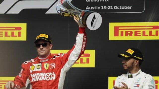 Kimi Raikkonen in cima al podio, festeggia e si prende gli applausi di Lewis Hamilton. Ap