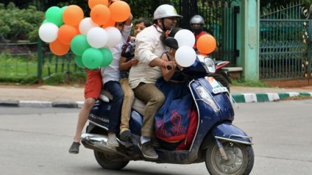 Una famiglia in scooter durante il giorno della festa d’indipendenza indiana. Afp