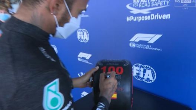 Lewis Hamilton firma la gomma simbolica dopo la pole numero 100 in carriera. Sky Sport