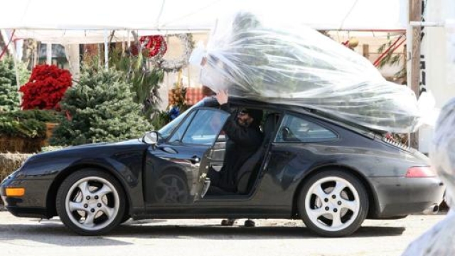 L’attore canadese con la sua Porsche: sul tetto un albero di Natale