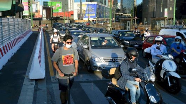 Monopattini, scooter e automobili in colonna a Milano. Ansa