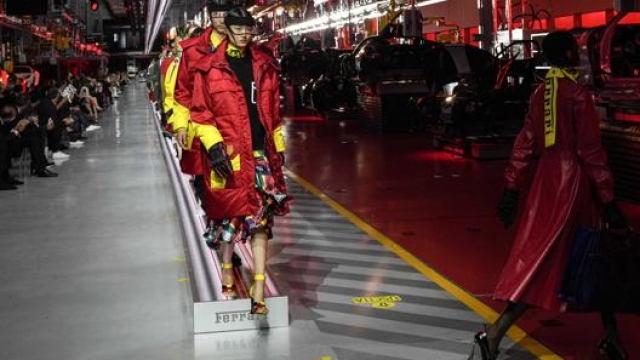 La linea di assemblaggio Ferrari è diventata una passerella dove modelle e modelli hanno presentato la nuova linea di abbigliamento del Cavallino