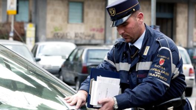 Un ausiliario del traffico di Roma mentre commina una multa