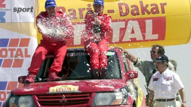 Da sinistra il copilota Andreas Schulz e la pilota Jutta Kleinschmidt sul Mitsubishi Pajero dopo la vittoria della Dakar 2001. Ap