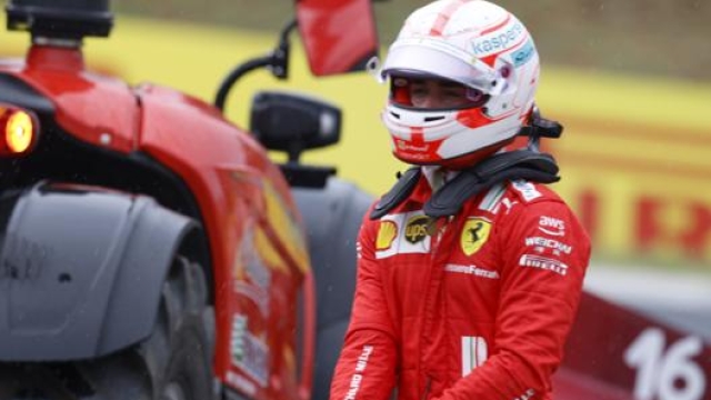 Charles Leclerc sconsolato mentre la sua Ferrari viene portata via