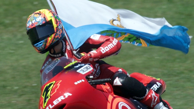 Manuel Poggiali che festeggia con  la bandiera della sua San Marino