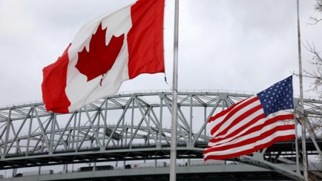 Le bandiere nazionali  e la fila di camion al Blue Water Bridge. Afp