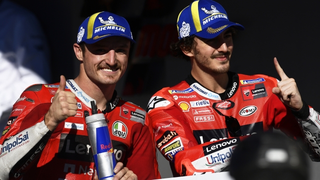 MotoGP riders Jack Miller of Australia and Francesco Bagnaia of Italy, right, gesture after finishing the Algarve Motorcycle Grand Prix, at the Algarve International circuit near Portimao, Portugal, Sunday, Nov. 7, 2021. Bagnaia won the race and Miller was third.(AP Photo/Jose Breton)