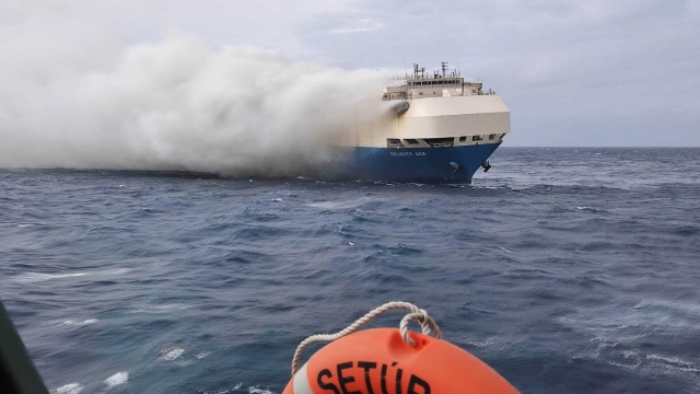 In this undated photo provided by the Portuguese Navy, smoke billows from the burning Felicity Ace car transport ship as seen from the Portuguese Navy NPR Setubal ship southeast of the mid-Atlantic Portuguese Azores Islands. The ship's crew were taken by helicopter to Faial island on the archipelago, about 170 kilometers (100 miles) away on Wednesday, Feb. 16, 2022. There were no reported injuries. (Portuguese Air Force via AP)