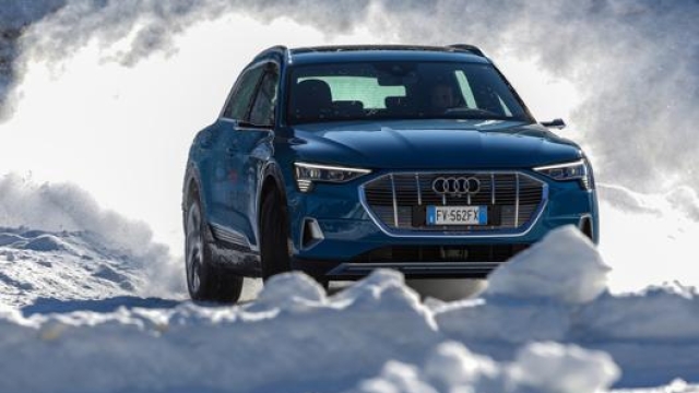 Una Audi e-tron l’elettrica quattro ruote motrici che si muove sulla pista di neve ricavata sul lago ghiacciato. RED