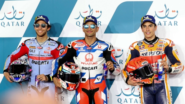 (L to R) Second-place Gresini Racing MotoGP team's Italian rider Enea Bastianini, first-place Pramac Racing's Spanish rider Jorge Martin, and third-place Repsol Honda Team's Spanish rider Marc Marquez celebrate on the podium following the second qualifying session ahead of the Moto GP Grand Prix of Qatar at the Lusail International Circuit, in the city of Lusail on March 5, 2022. (Photo by DENOUR / AFP)