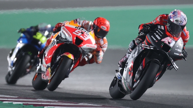 Aprilia Racing Team Gresini's Spanish rider Aleix Espargaro (R) and Repsol Honda Team's Spanish rider Marc Marquez (C) compete during the Moto GP Grand Prix of Qatar at the Lusail International Circuit, in the city of Lusail on March 6, 2022. (Photo by KARIM JAAFAR / AFP)