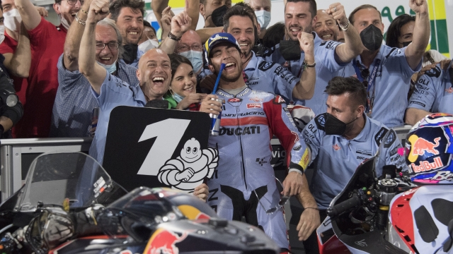 DOHA, QATAR - MARCH 06: Enea Bastianini of Italy and Gresini Racing MotoGP celebrates the victory with team under the podium during the MotoGP race during the MotoGP of Qatar at Losail Circuit on March 06, 2022 in Doha, Qatar. (Photo by Mirco Lazzari gp/Getty Images,)