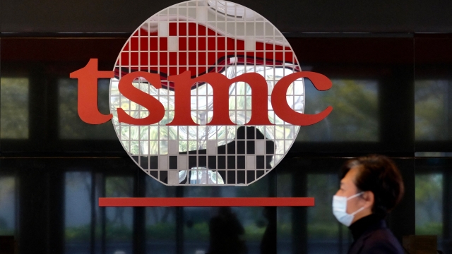 (FILES) This file photo taken on January 29, 2021 shows a man walking past the company logo of the world's largest semiconductor maker Taiwan Semiconductor Manufacturing Company (TSMC) in Hsinchu. - Consumer goods from smartphones to consoles could rise in price due to microchip shortages caused by a "perfect storm" of coronavirus-driven demand, supply chain disruptions and trade war stockpiling, experts warned on February 18, 2021. (Photo by Sam Yeh / AFP) / TO GO WITH Asia-economy-semiconductors-technology,FOCUS by Sam REEVES