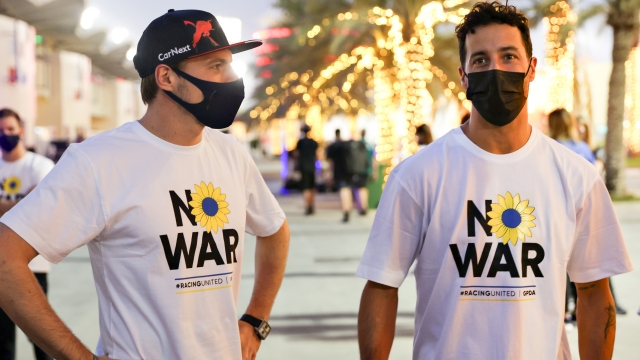 BAHRAIN, BAHRAIN - MARCH 09: Max Verstappen of the Netherlands and Oracle Red Bull Racing and Daniel Ricciardo of Australia and McLaren talk while wearing t-shirts promoting peace and sympathy with Ukraine prior to F1 Testing at Bahrain International Circuit on March 09, 2022 in Bahrain, Bahrain. (Photo by Mark Thompson/Getty Images)