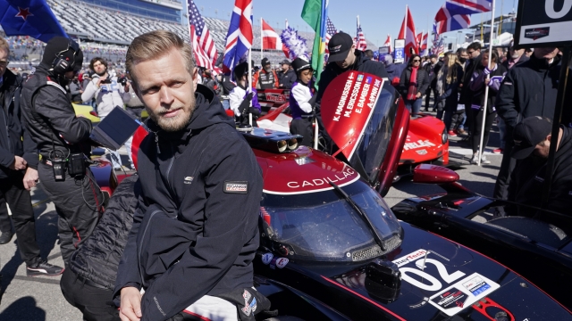 Kevin Magnussen, of Denmark, leans against his car on pit road before the start of the Rolex 24 hour auto race at Daytona International Speedway, Saturday, Jan. 29, 2022, in Daytona Beach, Fla. (AP Photo/John Raoux)
