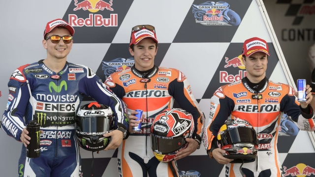 Spanish bikers (L-R): Jorge Lorenzo, second placed with Yamaha; Marc Marquez, winning the pole position with Honda and his teammate  Dani Pedrosa, who got the third position with Honda, pose at the end of the the MotoGP qualifying round of the Argentina Grand Prix at Termas de Rio Hondo circuit, in Santiago del Estero, Argentina on April 26, 2014. AFP PHOTO / Juan Mabromata