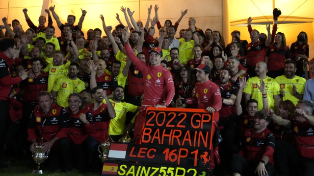 Ferrari driver Charles Leclerc of Monaco, left, and Ferrari driver Carlos Sainz of Spain pose for photograph with team members celebrating winning the first and second positions during the Bahrain Formula One Grand Prix at the Formula One Bahrain International Circuit in Sakhir, Bahrain, Sunday, March 20, 2022. (AP Photo/Hassan Ammar)
