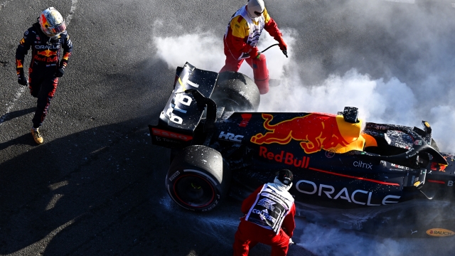 Max Verstappen vicino alla sua Red Bull in fiamme