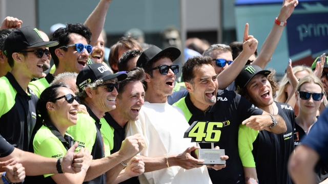 Nine time World Champion, Italy's Valentino Rossi (C), poses with members of Team Mooney VR46 during a retirement ceremony of his iconic number 46, ahead the Italian Moto GP Grand Prix at the Mugello race track, Tuscany, on May 28, 2022. (Photo by Filippo MONTEFORTE / AFP)