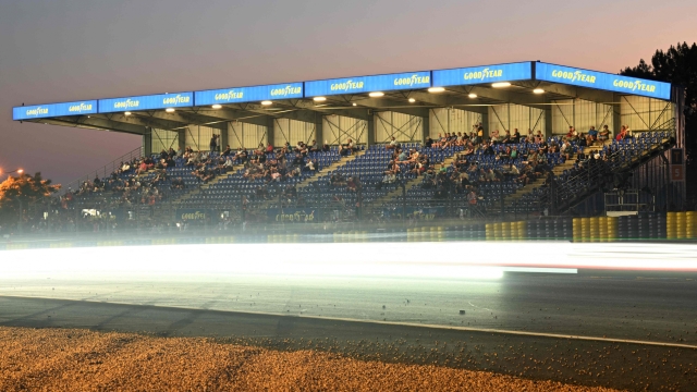 WEC racing cars pass by a tribune during the 90th edition of the Le Mans 24 Hours endurance race, in Le Mans, north-western France, on June 11, 2022. (Photo by Damien MEYER / AFP)