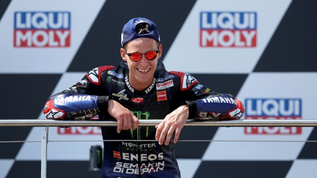 Monster Energy Yamaha's French rider Fabio Quartararo celebrates on the podium after winning the German MotoGP Grand Prix at the Sachsenring racing circuit in Hohenstein-Ernstthal near Chemnitz, eastern Germany, on June 19, 2022. (Photo by Ronny Hartmann / AFP)