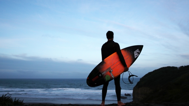 Un surfista solitario controlla il mare. Ph. Fiona Goodall/Getty Images