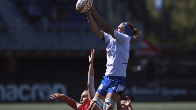 Team Canada players, botto, cannot stop the throw in as Team Italy's Elisa Giordano, top, makes a catch during first-half test match rugby action in Langford, British Columbia, Sunday, July 24, 2022. (Chad Hipolito/The Canadian Press via AP)