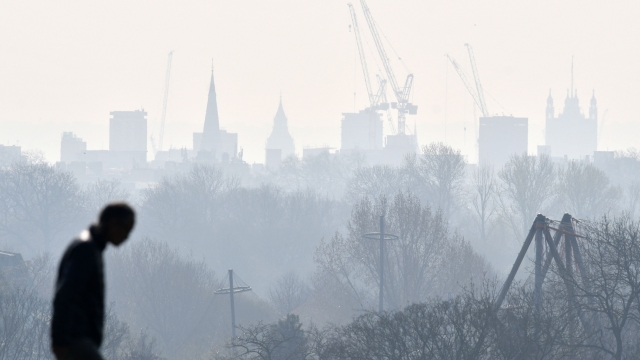 A visitor walks at Primrose Hill as a high air pollution warning was issued for London on March 24, 2022. (Photo by JUSTIN TALLIS / AFP)