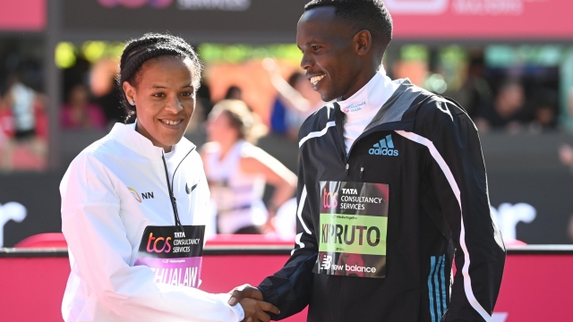epa10219304 Yalemzerf Yehualaw (L) of Ethiopia and Amos Kipruto of Kenya pose for photographs after winning the women's and men's elite race respectively at the 2022 TCS London Marathon in London,  Britain, 02 October 2022.  EPA/NEIL HALL