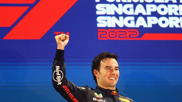 SINGAPORE, SINGAPORE - OCTOBER 02: Race winner Sergio Perez of Mexico and Oracle Red Bull Racing celebrates on the podium during the F1 Grand Prix of Singapore at Marina Bay Street Circuit on October 02, 2022 in Singapore, Singapore. (Photo by Mark Thompson/Getty Images,)