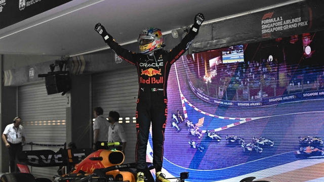 Winner Red Bull Racing's Mexican driver Sergio Perez celebrates after the Formula One Singapore Grand Prix night race at the Marina Bay Street Circuit in Singapore on October 2, 2022. (Photo by Lillian SUWANRUMPHA / AFP)