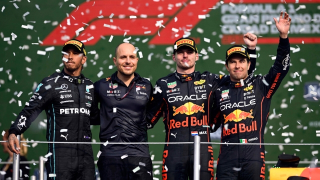 Red Bull Racing's Dutch driver Max Verstappen (3-L) celebrates on the podium with second place Mercedes' British driver Lewis Hamilton (L), third place Red Bull Racing's Mexican driver Sergio Perez and Red Bull Racing's race engineer Gianpiero Lambiase after the Formula One Mexico Grand Prix at the Hermanos Rodriguez racetrack in Mexico City on October 30, 2022. (Photo by Alfredo ESTRELLA / AFP)