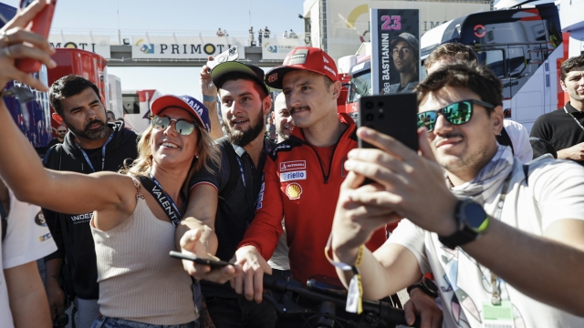 epa10287729 Moto GP rider Francesco Bagnaia (C-R) of Italy poses with supporters ahead of a training session at Ricardo Tormo Circuit in Cheste, Valencia, 05 November 2022. Comunidad Valenciana Motorciclyng Grand Prix, the last Grand Prix of the season, is to take place on 06 November 2022.  EPA/BIEL ALINO