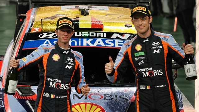 Rally Japan 2022 winner Thierry Neuville (centre R) and his co-driver Martijn Wydaeghe (centre L) of Belgium pose in front of their Hyundai i20 N Rally1 Hybrid on the podium during the ceremonial finish in the Rally Japan, the 13th and final round of the FIA World Rally Championships, in Toyota city on November 13, 2022. (Photo by Toshifumi KITAMURA / AFP)