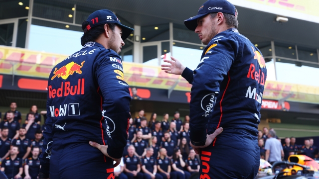 ABU DHABI, UNITED ARAB EMIRATES - NOVEMBER 17: Max Verstappen of the Netherlands and Oracle Red Bull Racing and Sergio Perez of Mexico and Oracle Red Bull Racing talk ahead of the Red Bull Racing end of season team photo during previews ahead of the F1 Grand Prix of Abu Dhabi at Yas Marina Circuit on November 17, 2022 in Abu Dhabi, United Arab Emirates. (Photo by Bryn Lennon/Getty Images)