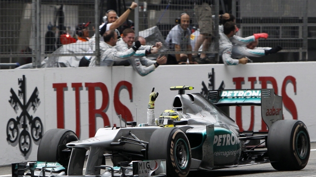 epa03183319 German Formula One driver Nico Rosberg of Mercedes AMG celebrates as he passes before his mechanics after winning the 2012 China Formula One Grand Prix at the Shanghai International circuit in Shanghai, China, 15 April 2012. Rosberg won his first ever F1 Grand Prix ahead of British Formula One drivers Jenson Button and Lewis Hamilton of McLaren Mercedes.  EPA/HOW HWEE YOUNG