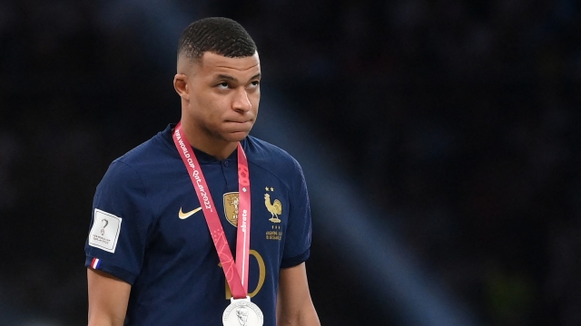 France's forward #10 Kylian Mbappe looks up after receiving his silver medal during the Qatar 2022 World Cup trophy ceremony after the football final match between Argentina and France at Lusail Stadium in Lusail, north of Doha on December 18, 2022. - Argentina won in the penalty shoot-out. (Photo by FRANCK FIFE / AFP)