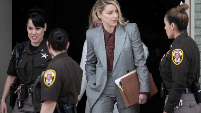(FILES) In this file photo taken on May 26, 2022 Actor Amber Heard leaves for the day during the Depp vs Heard deformation trial at Fairfax County Court in Fairfax, Virginia. - Actress Amber Heard announced December 18, 2022 that she had reached a settlement in the multi-million dollar defamation case filed against her by her former husband Johnny Depp. (Photo by Brendan Smialowski / AFP)