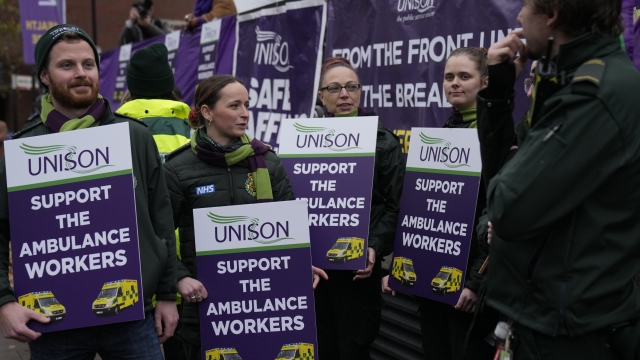Ambulance workers go on strike and hold placards as they join the picket line outside the Headquarters of the London Ambulance Service in London, Wednesday, Dec. 21, 2022. (AP Photo/Alastair Grant)