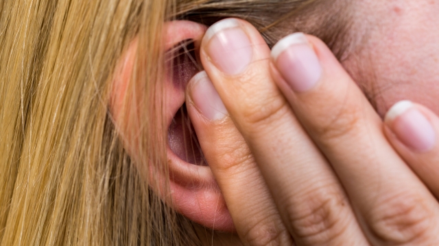 Woman lays finger on the ear