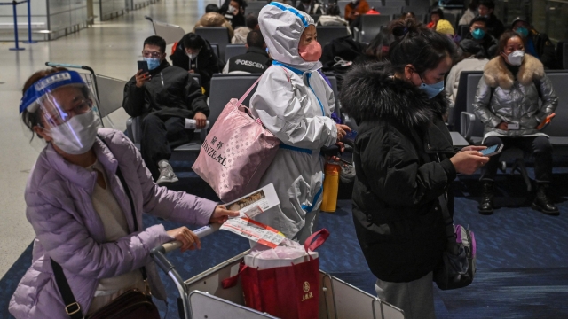 A passenger wearing protective clothing amid the Covid-19 pandemic waits to board a domestic flight at Shanghai Pudong International Airport in Shanghai on January 3, 2023. (Photo by HECTOR RETAMAL / AFP)